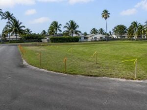 Survey stakes marking adjusted lot frontage along a curved residential road in Hollywood, Florida.