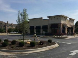 Commercial property with parking areas, drive aisles, landscaped islands, and surveying equipment in Hollywood, Florida.